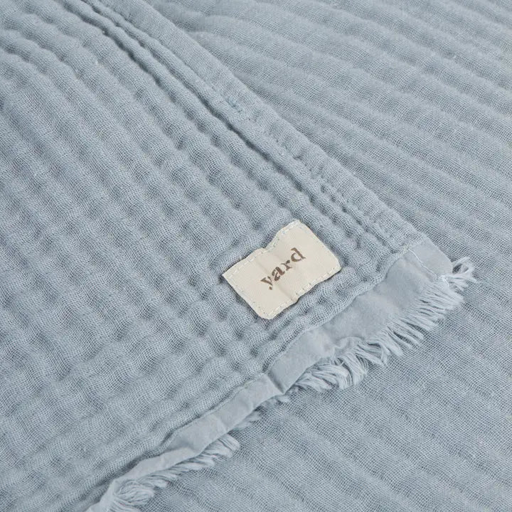Textured blue fabric with a 'yard' label