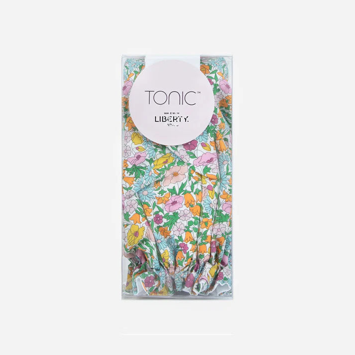 Floral patterned shower cap with Tonic and Liberty labels on a white background