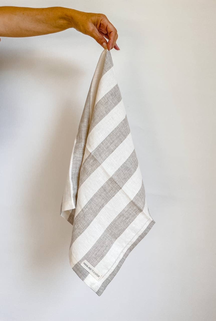Striped towel held by a hand against a plain background