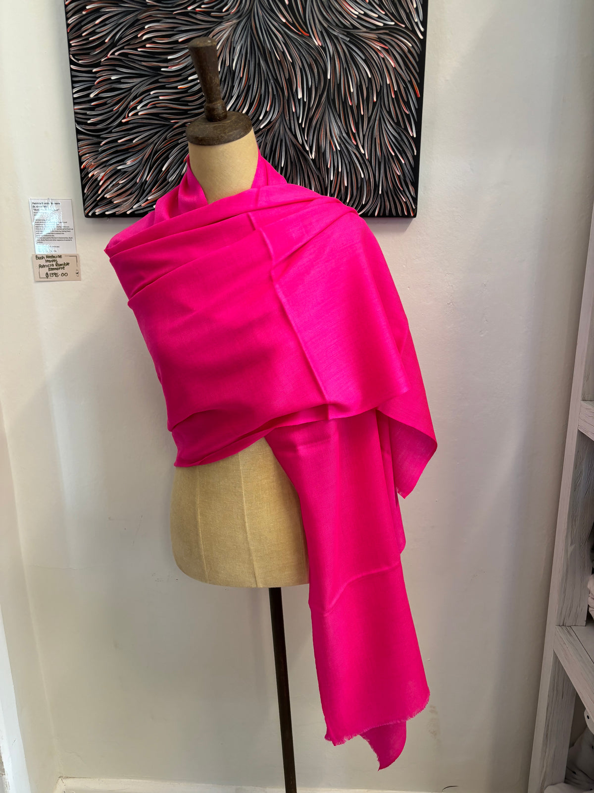 Mannequin wearing a bright pink dress with a neutral background