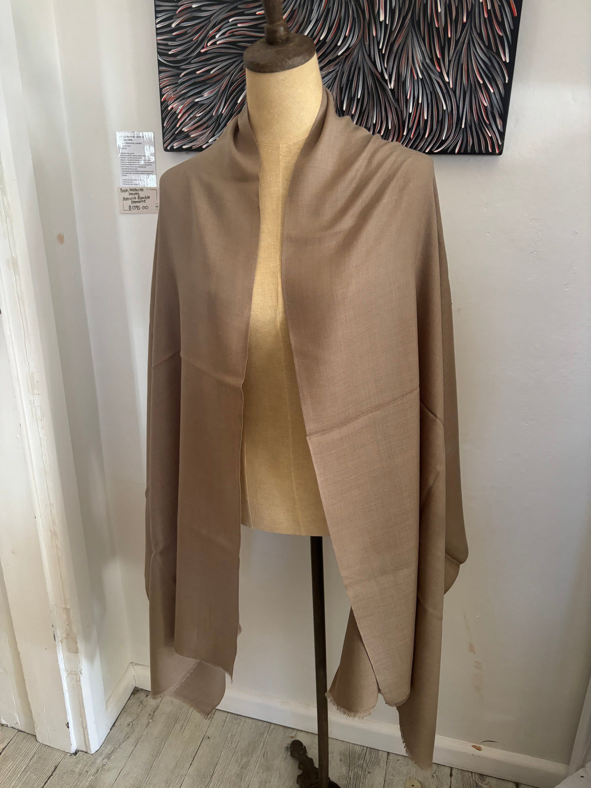 Mannequin wearing a beige fabric in a store setting