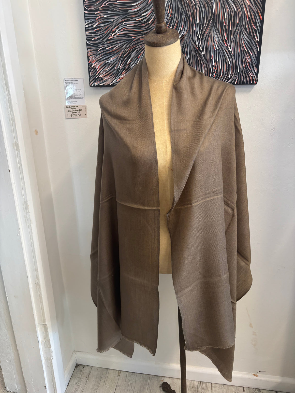 Mannequin wearing a brown fabric with a white background