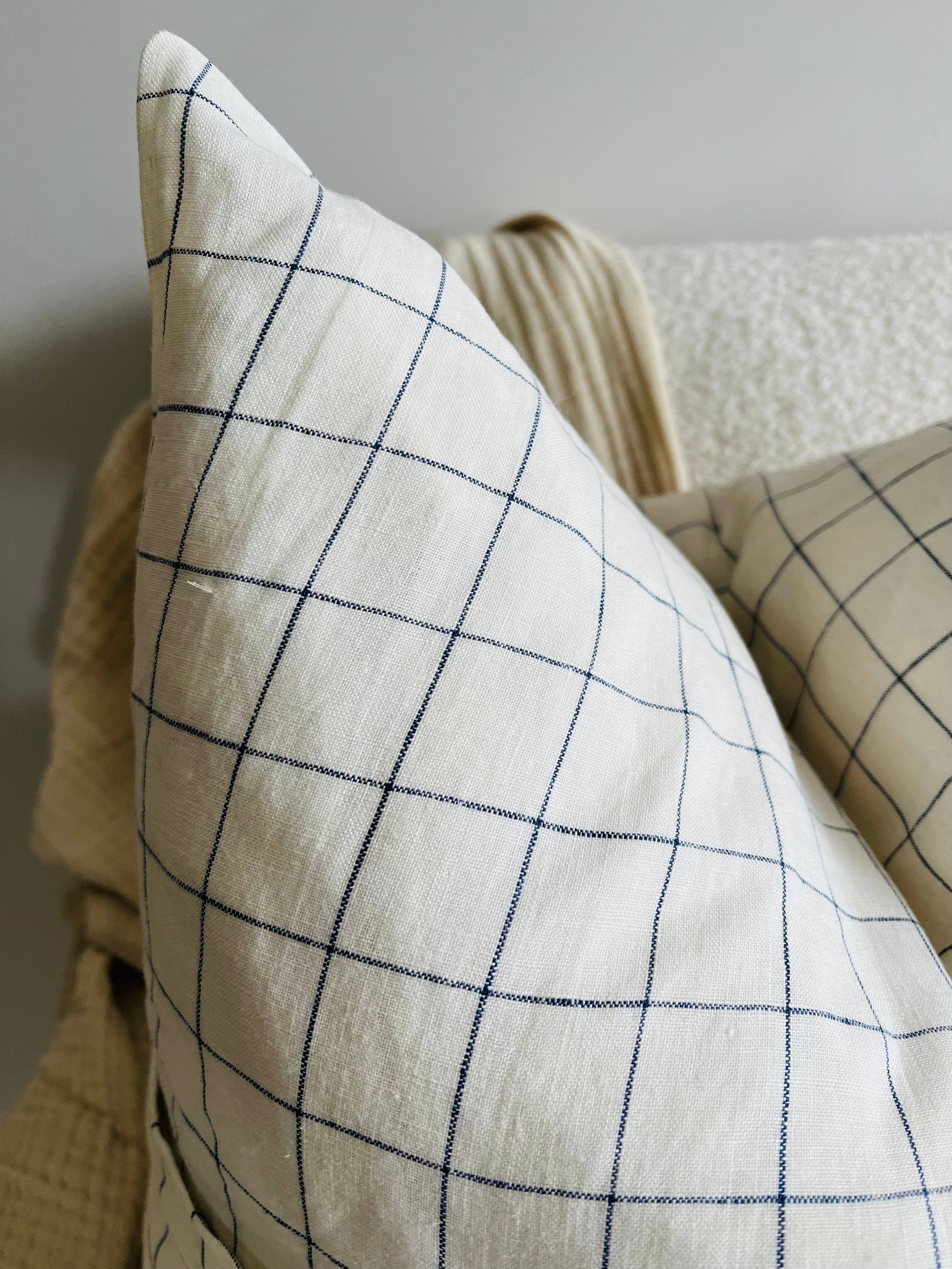 Close-up of a pillow with a grid pattern on a neutral background