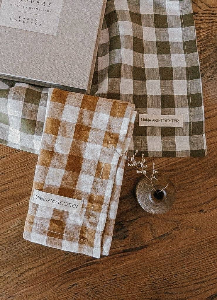 Checkered napkins with 'Mama and Tochter' label on a wooden surface