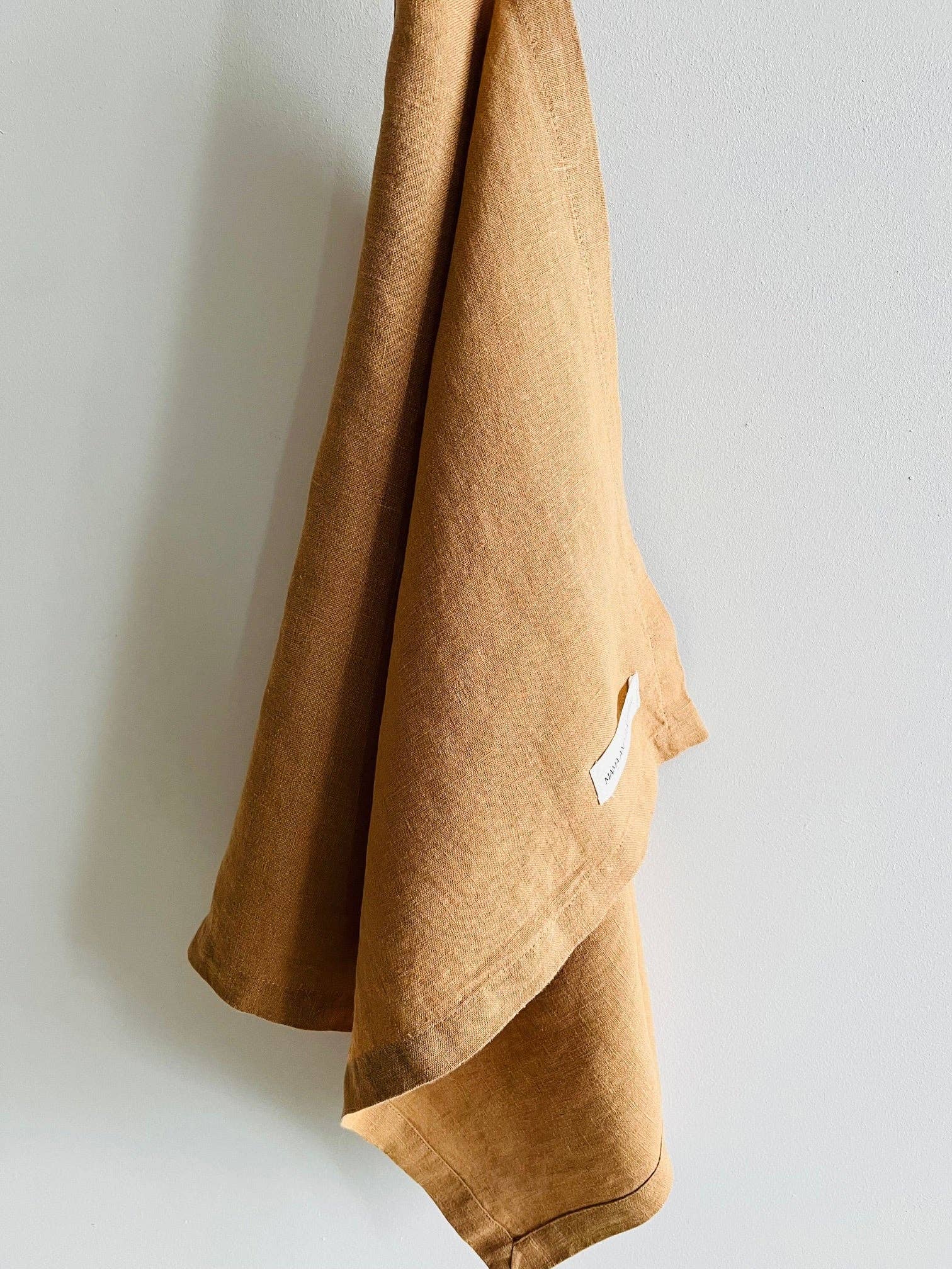 Brown towel hanging against a light gray wall