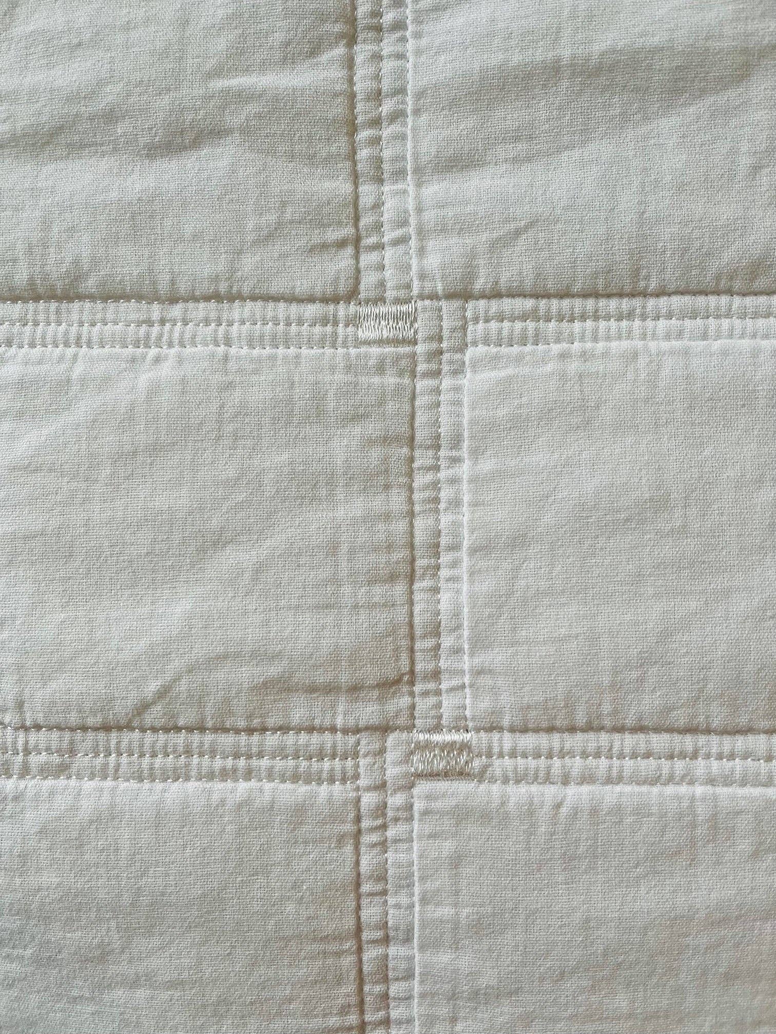 Close-up of a quilted fabric surface with visible stitching