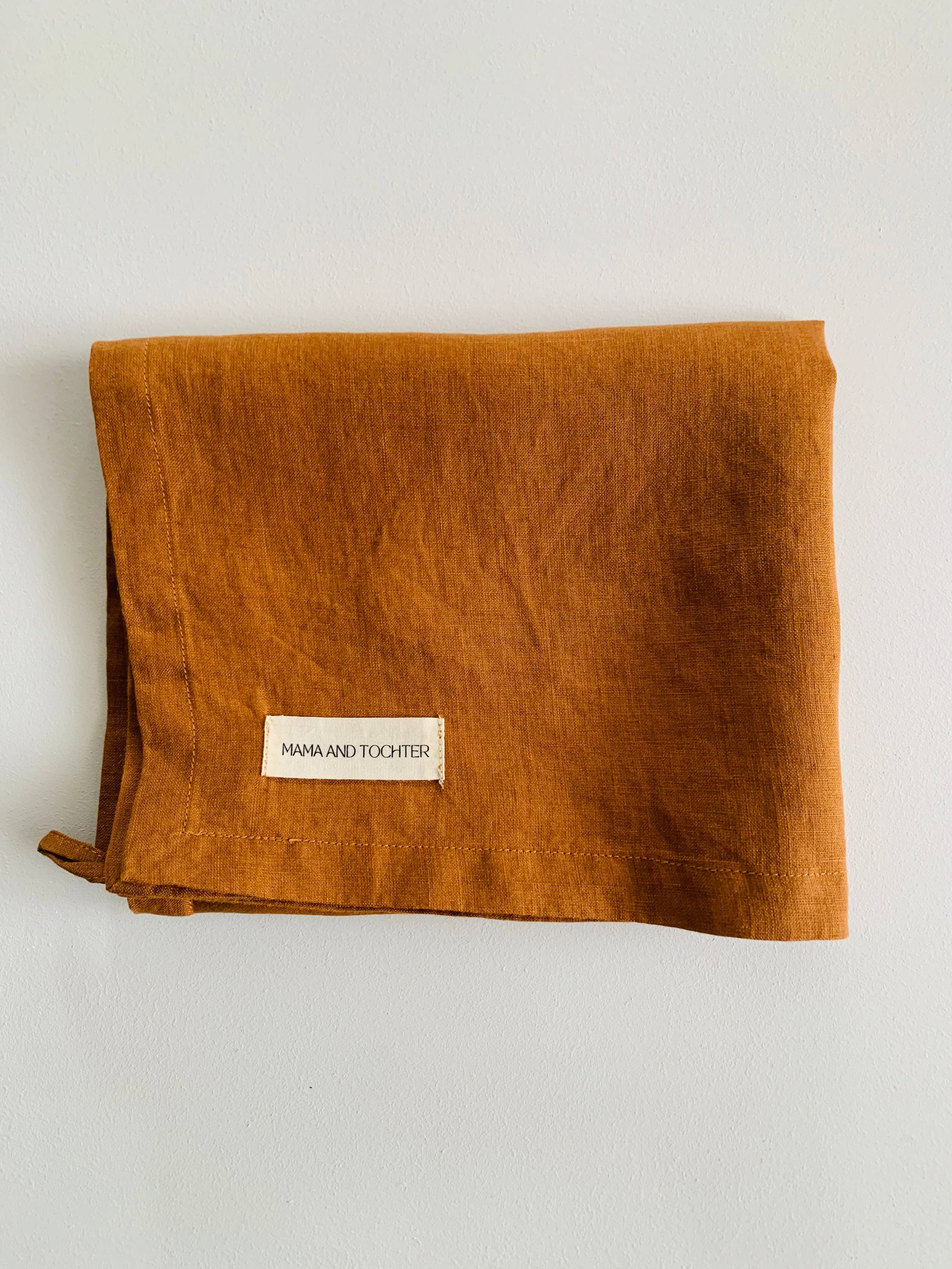 Folded brown fabric with a label on a light gray background