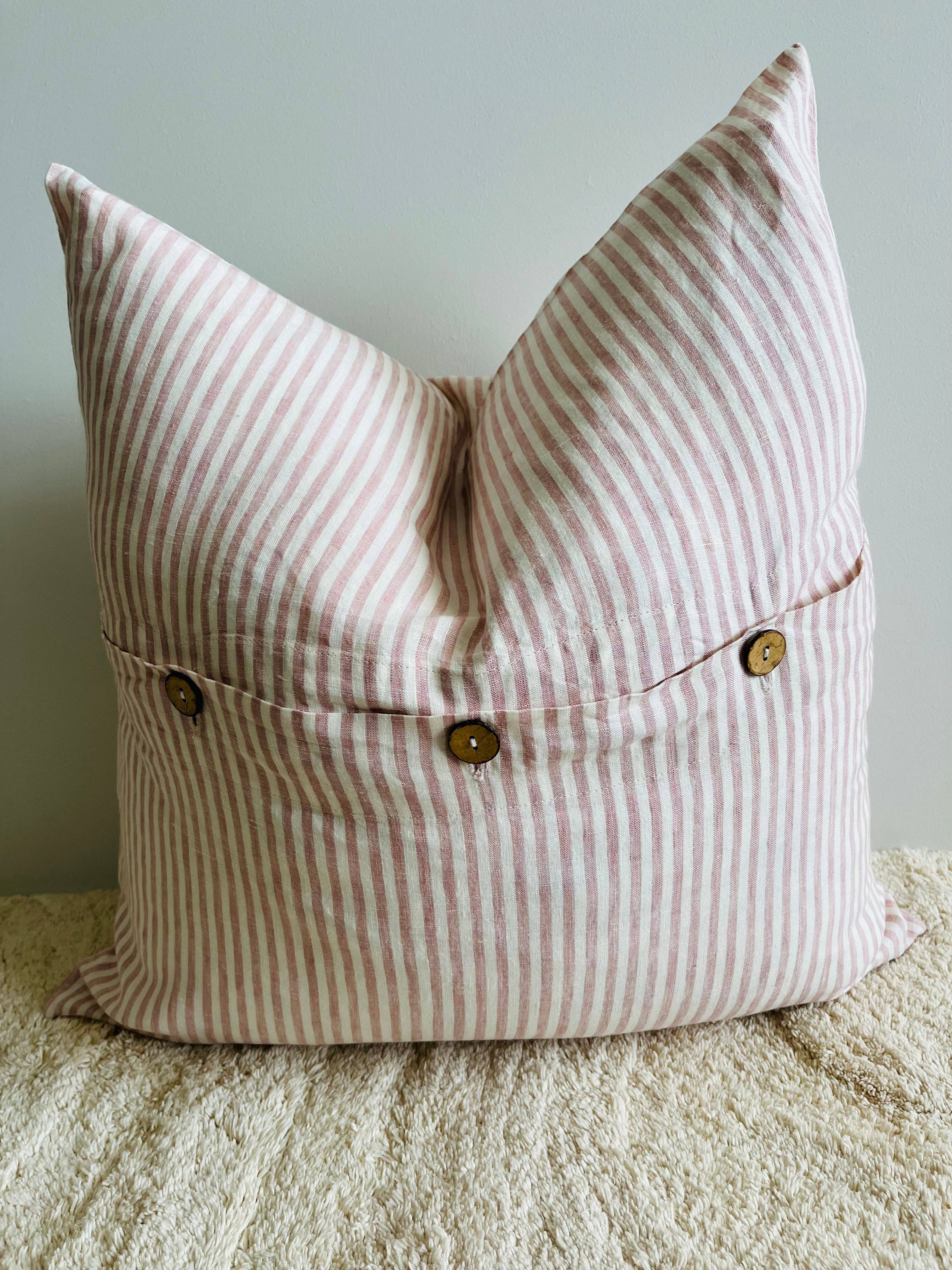 Striped pillow with button details on a neutral background