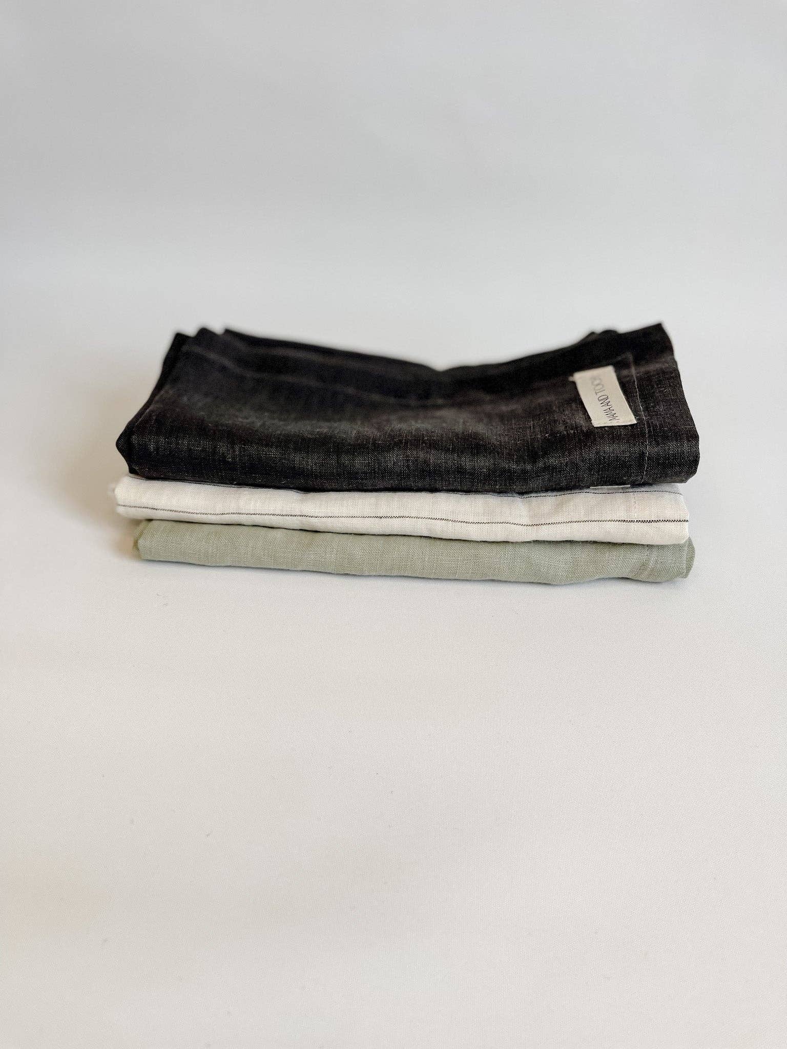 Three folded fabric towels on a light background