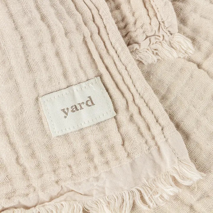 Beige textured fabric with a 'yard' label