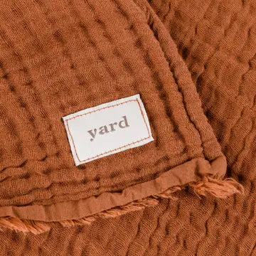 Brown textured fabric with a 'yard' label