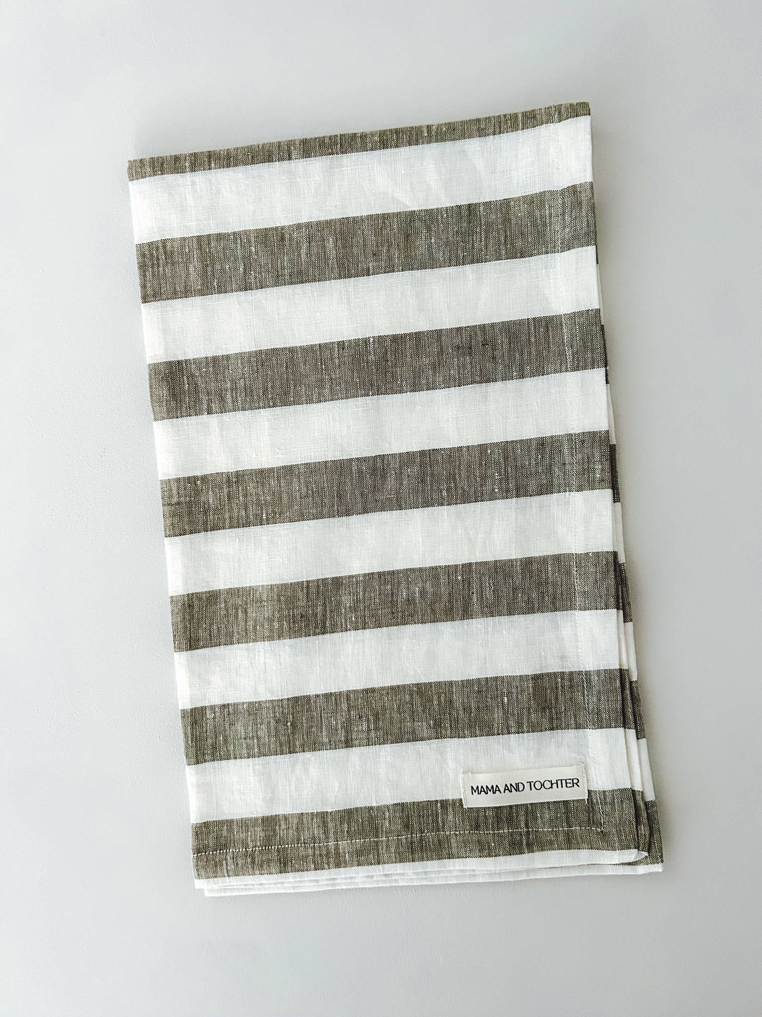 Striped towel with brown and white stripes on a light gray background