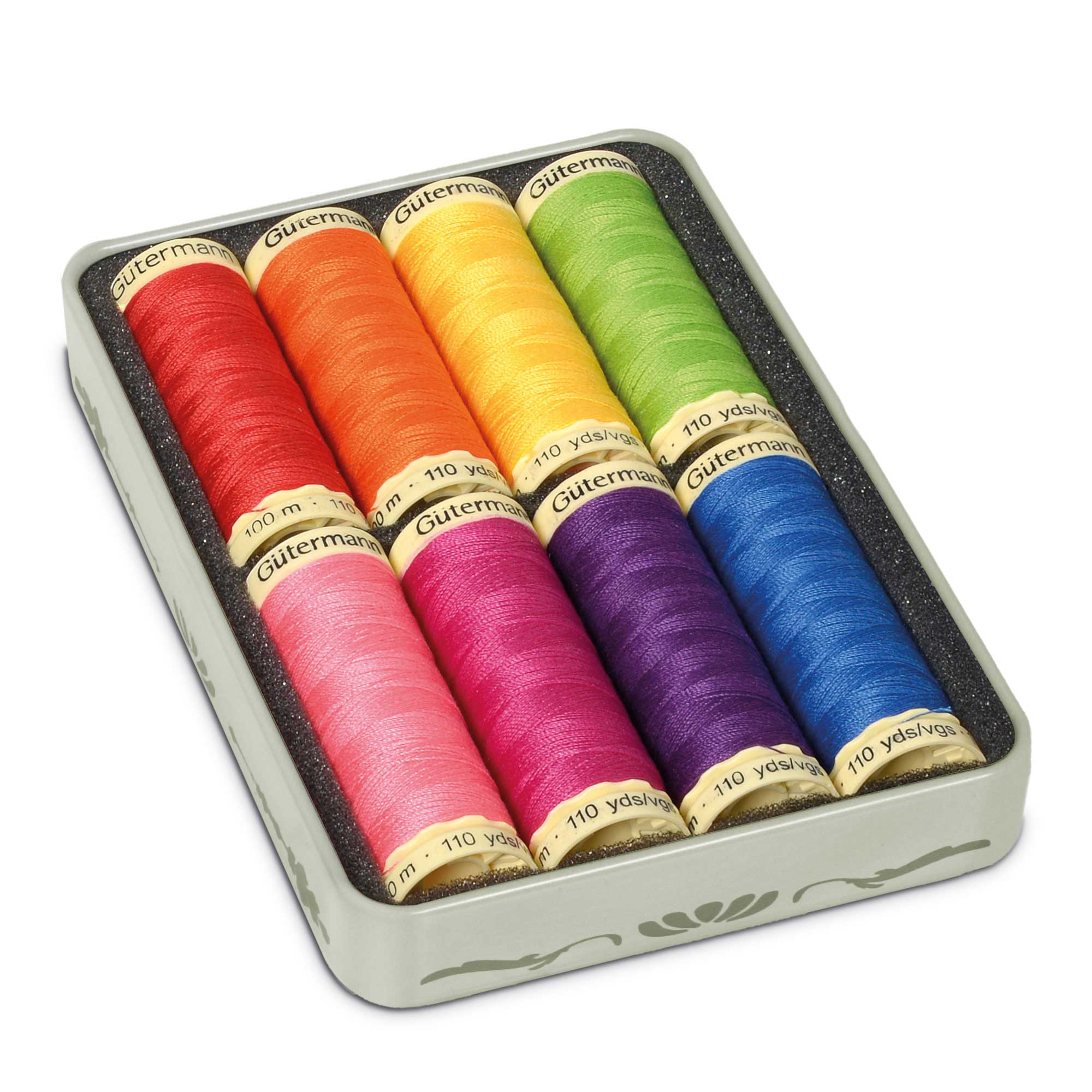 Set of colorful Gutermann thread spools in a tin box on a white background