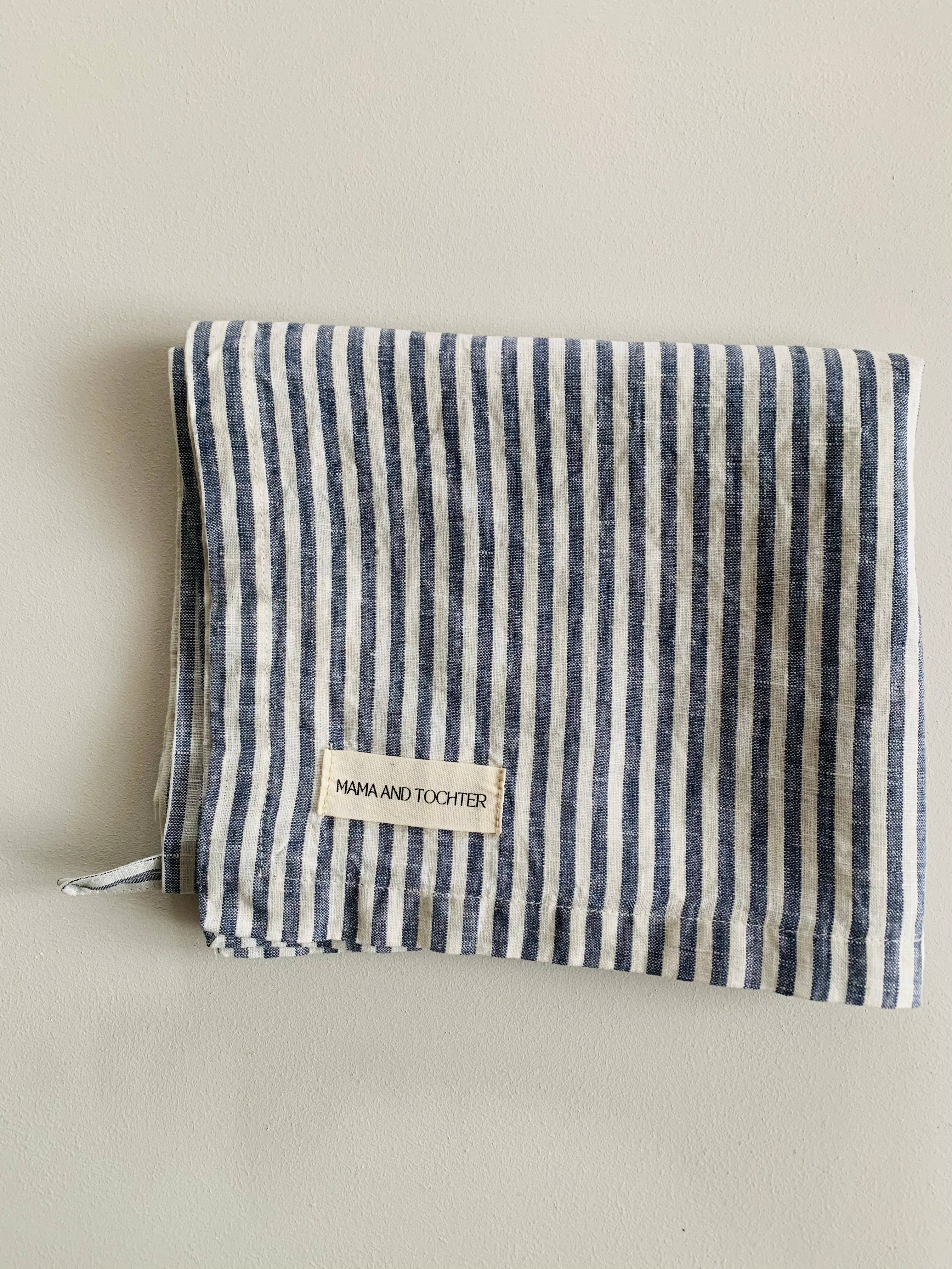 Striped pouch with a visible brand label on a beige background