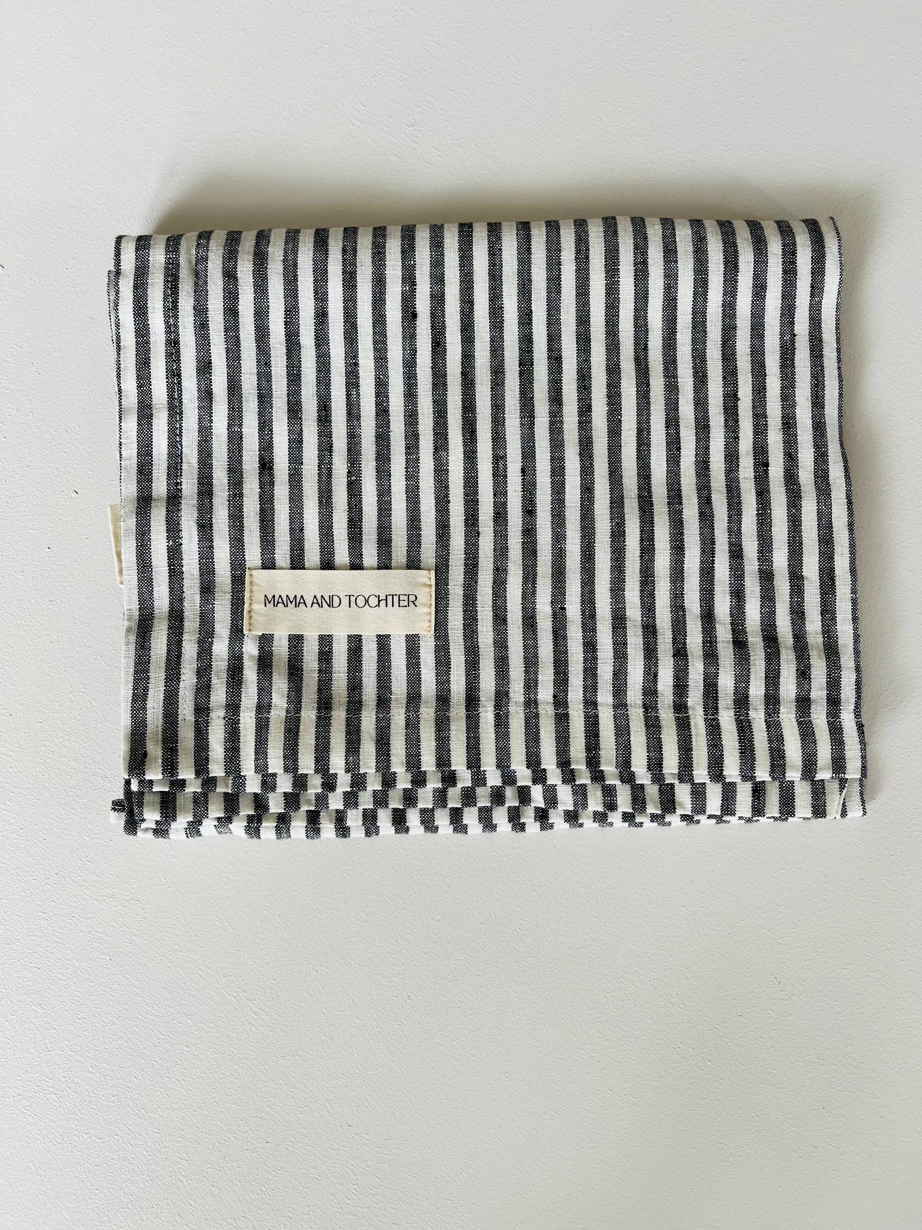 Black and white striped fabric with a label on a light gray background