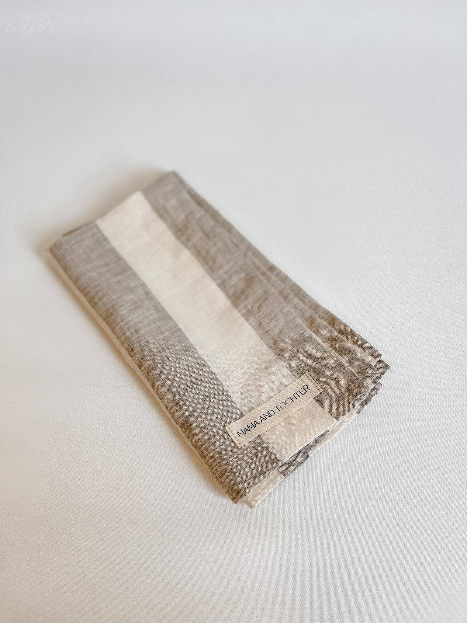 Folded fabric with a brand label on a light gray background