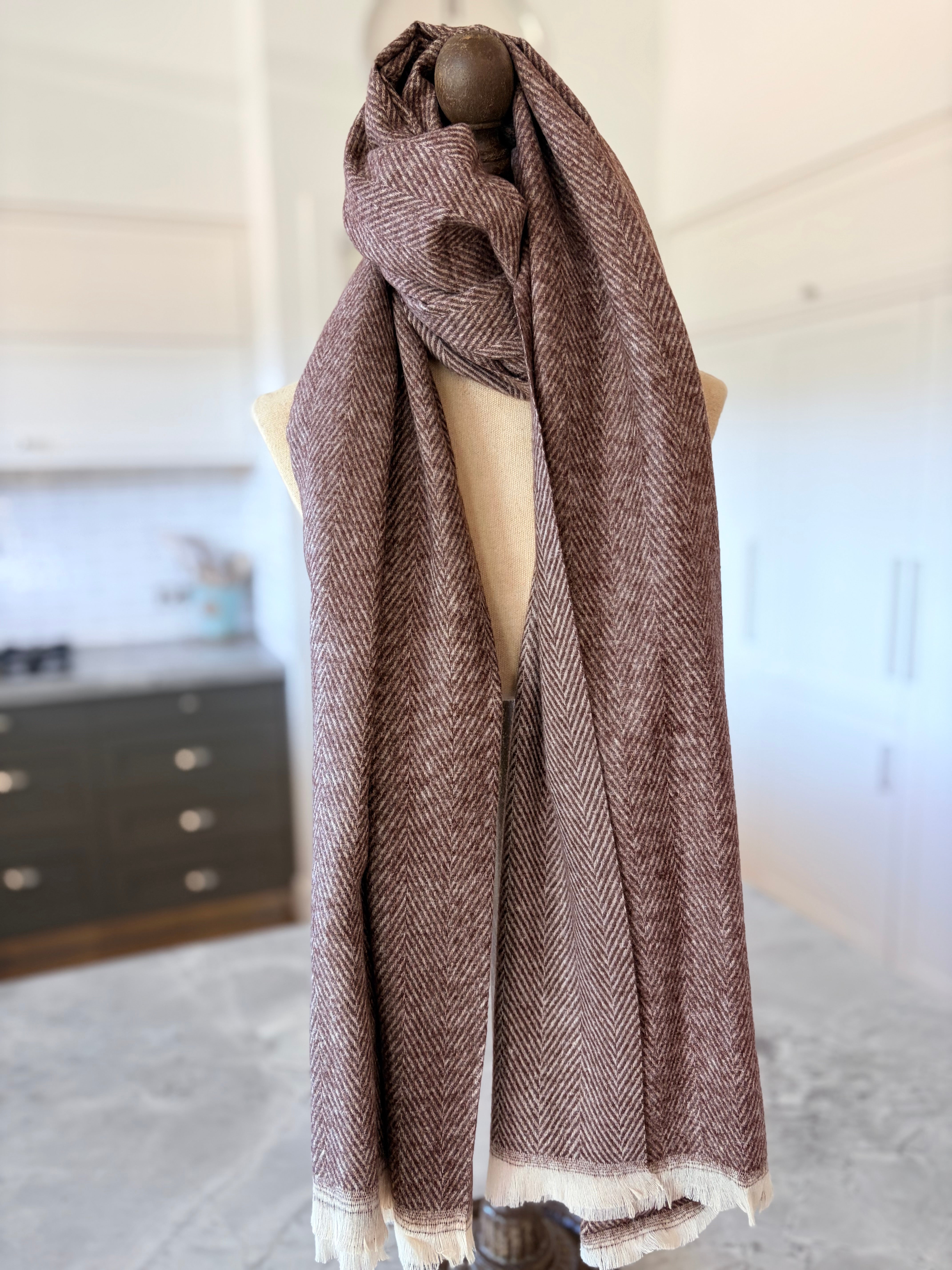 Brown herringbone patterned scarf on a mannequin in a room setting.