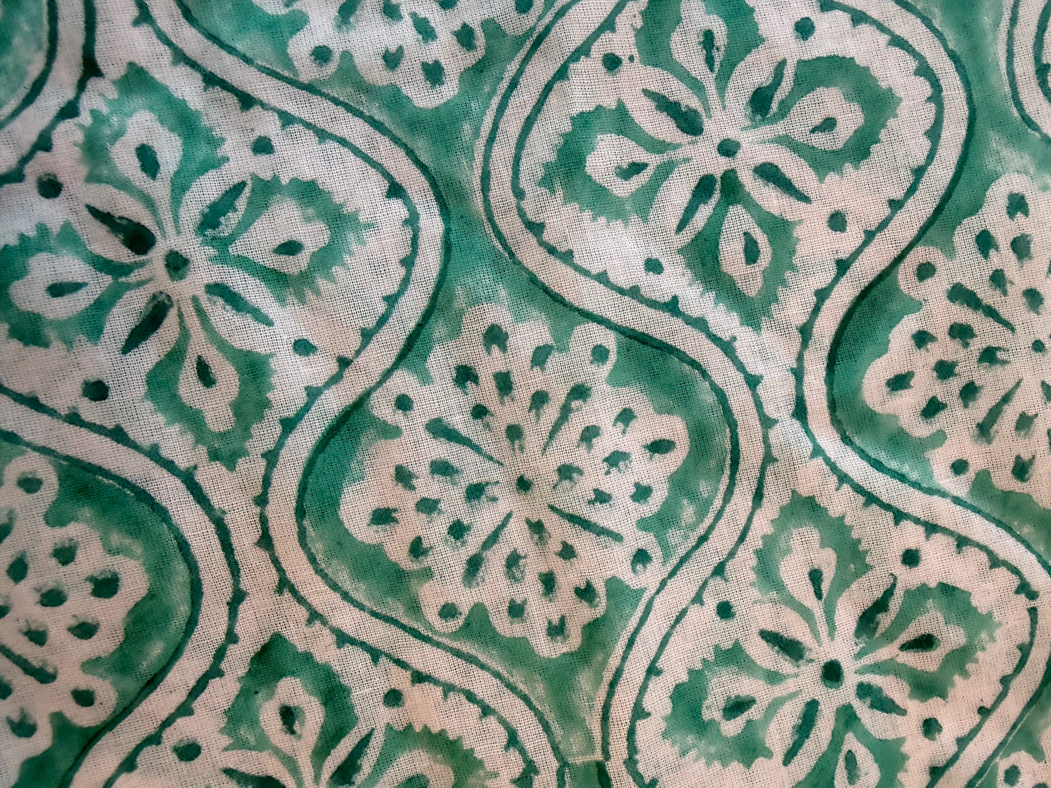 Close-up of a fabric with a green and beige floral pattern