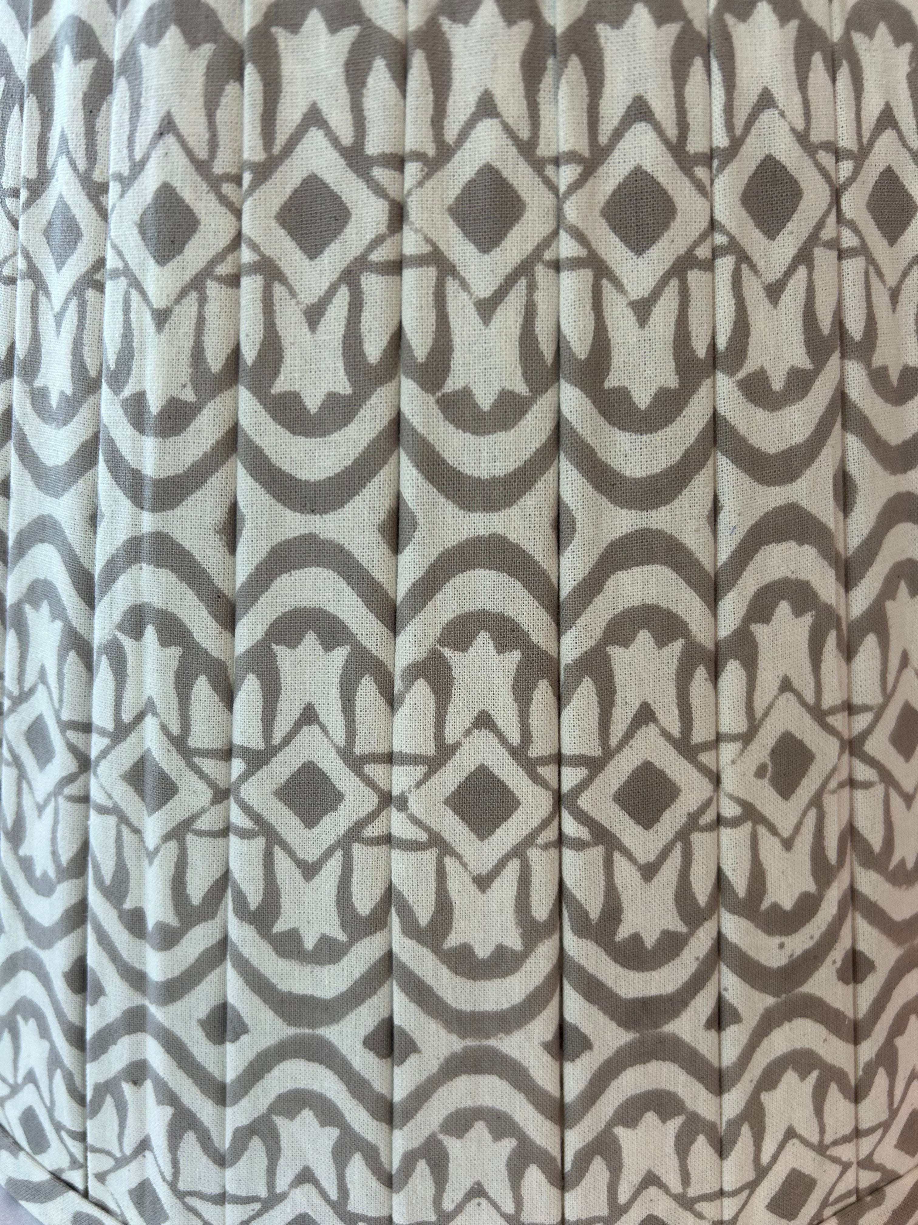 Patterned fabric with geometric design in grey and beige tones.