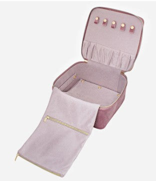 Pink jewelry case with open lid and folded fabric inside on a white background