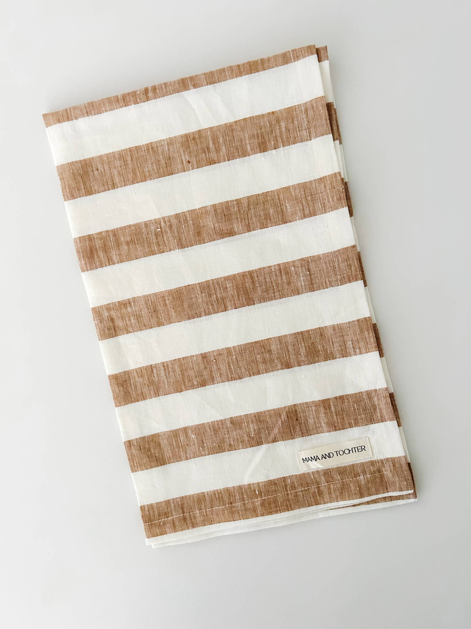 Striped towel with brown and white stripes on a light gray background