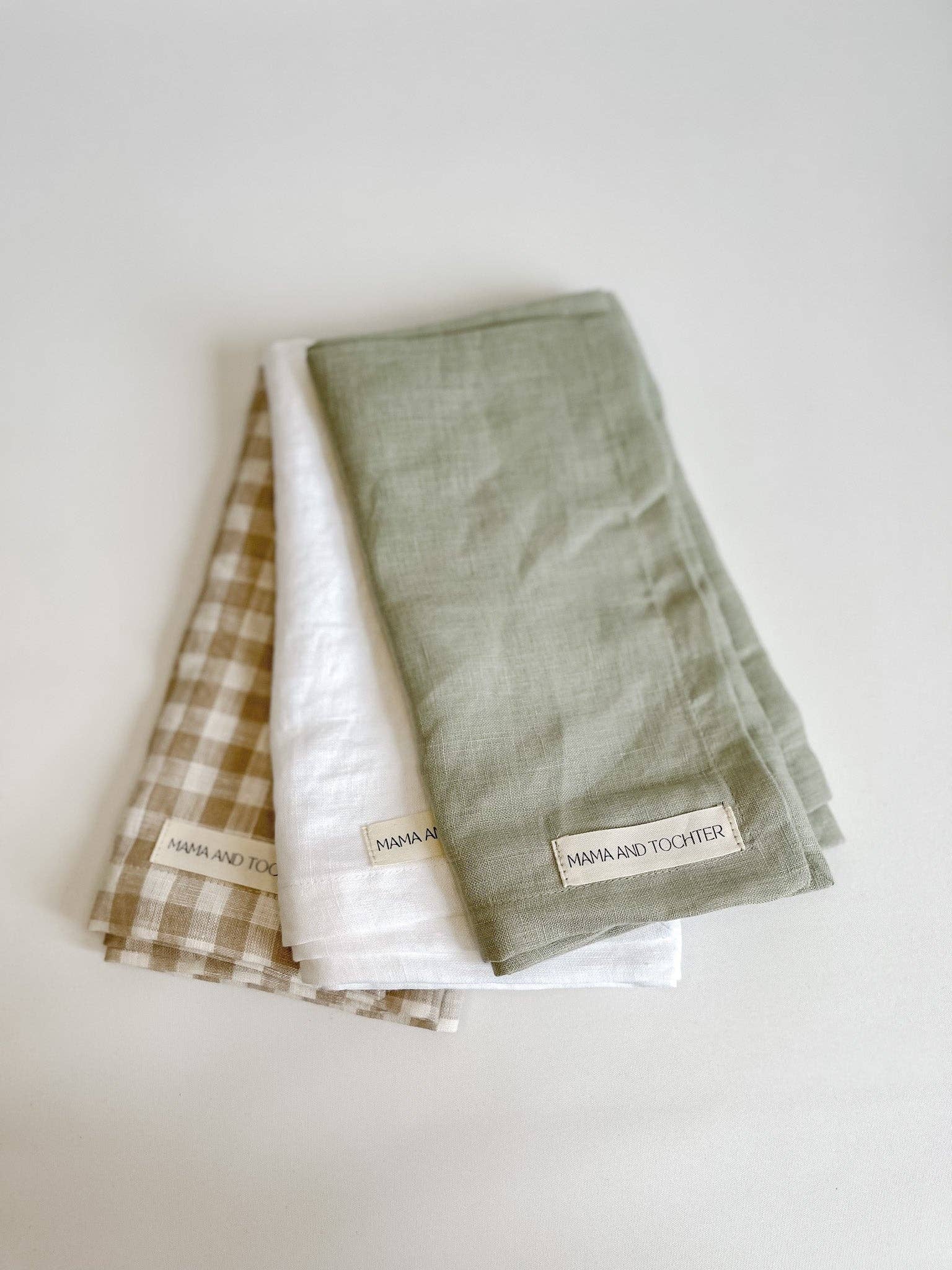 Three folded towels with labels on a white background