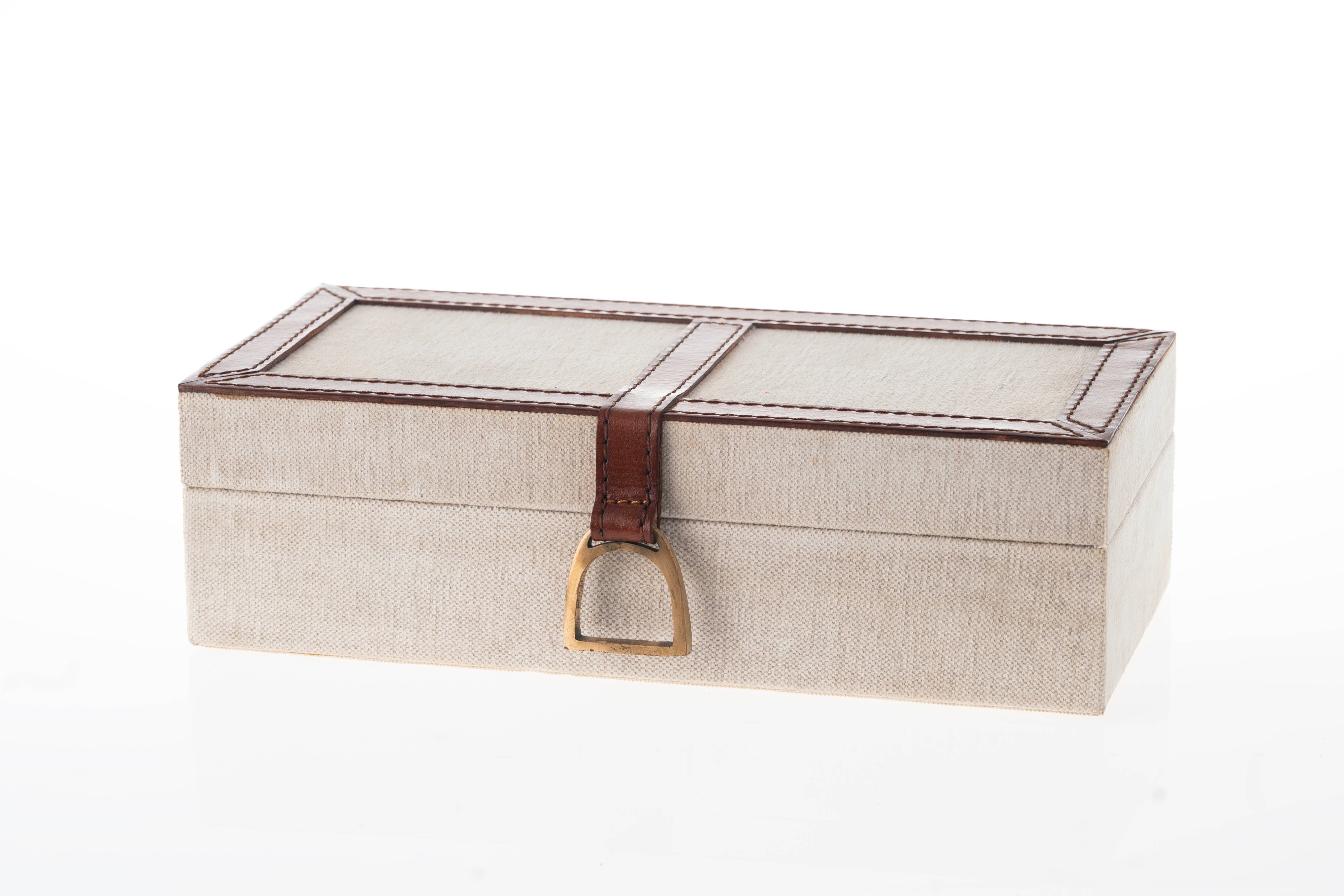 Beige jewelry box with a brown leather strap and gold clasp on a white background