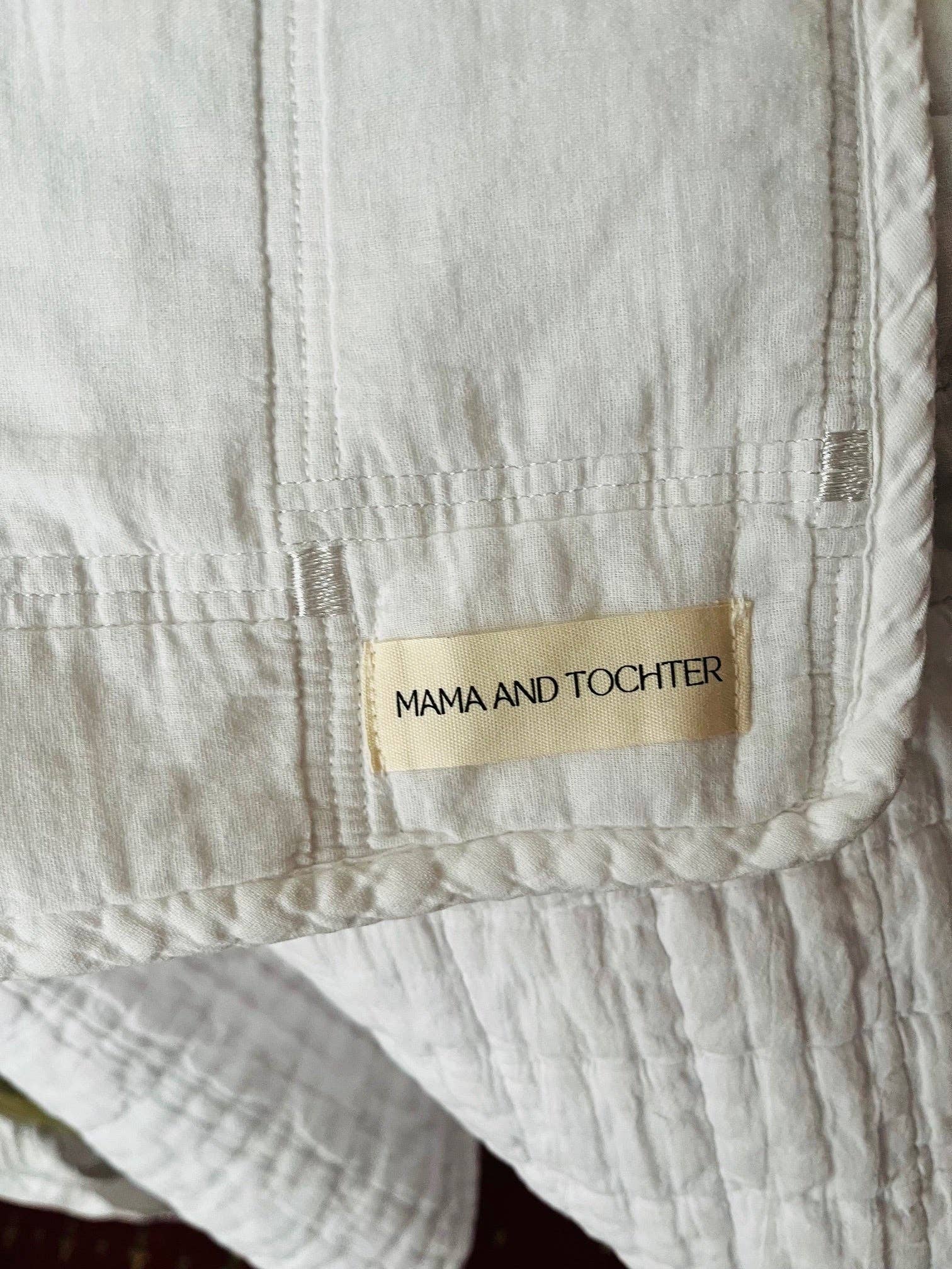 Close-up of a beige fabric with a 'MAMA AND TOCHTER' label.