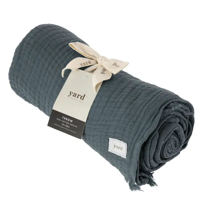 Rolled-up teal throw blanket with 'yard' brand tag on a white background