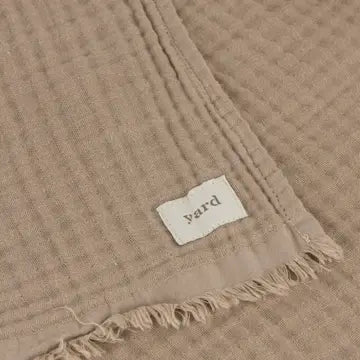 Beige woven fabric with a 'yard' label