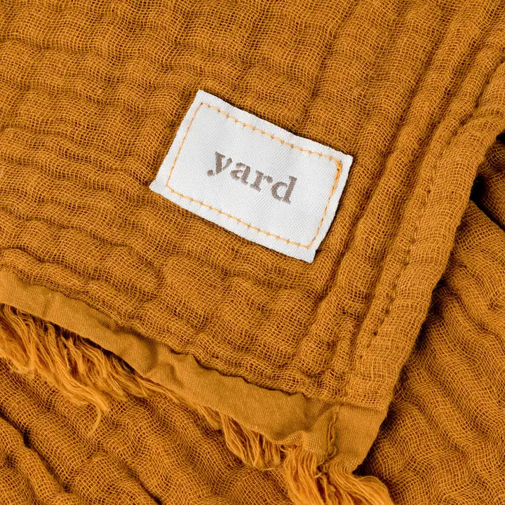 Mustard yellow fabric with a 'yard' label