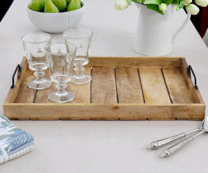 Wooden tray with glasses on a white surface