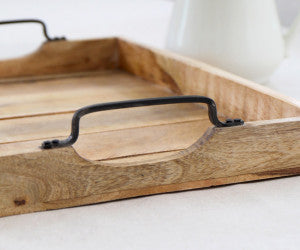 Wooden tray with a black handle on a white surface